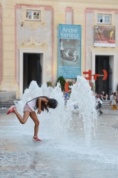 Genova, piazza de ferrari - ragazzini giocano con i getti d'acqu