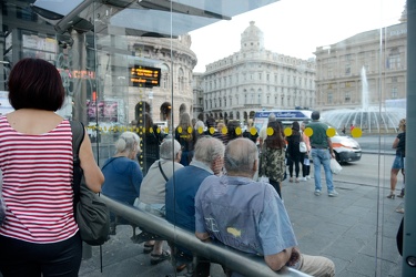 Genova, piazza De Ferrari - persone in attesa alla fermata dell'