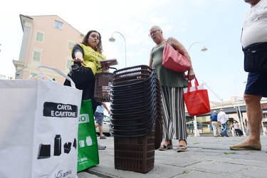 Genova, piazza Raibetta - incaricati distribuiscono bidoncini pe