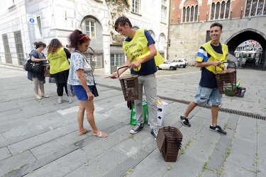 Genova, piazza Raibetta - incaricati distribuiscono bidoncini pe